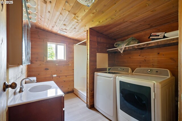 520 Elm Ave, Tillamook, OR 97141 - washroom featuring washing machine and clothes dryer, wooden walls, wood ceiling, and light wood-style flooring
