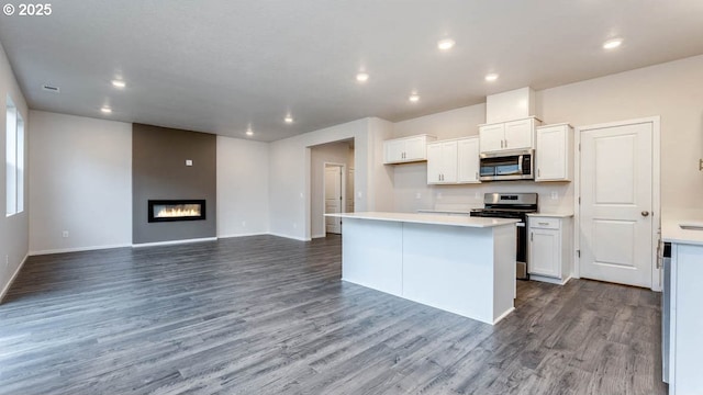 247 Stella St, Salem, OR 97301 - kitchen with stainless steel appliances, recessed lighting, dark wood-style floors, white cabinets, and a kitchen island