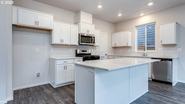 247 Stella St, Salem, OR 97301 - kitchen featuring appliances with stainless steel finishes, dark wood-style floors, white cabinets, a kitchen island, and recessed lighting