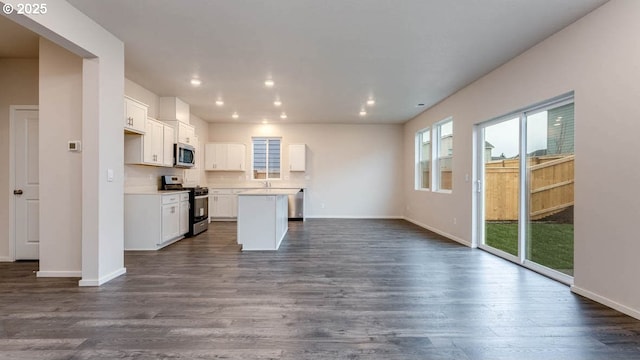 247 Stella St, Salem, OR 97301 - kitchen with stainless steel appliances, open floor plan, a center island, dark wood-style floors, and white cabinetry