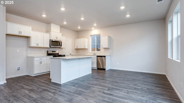247 Stella St, Salem, OR 97301 - kitchen featuring stainless steel appliances, white cabinetry, a center island, light countertops, and dark wood-type flooring