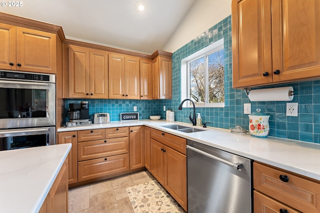 kitchen featuring lofted ceiling, light tile patterned floors, decorative backsplash, appliances with stainless steel finishes, and a sink