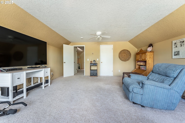 living room with lofted ceiling, carpet flooring, a ceiling fan, and a textured ceiling