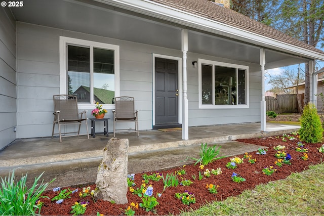 entrance to property with a porch and fence