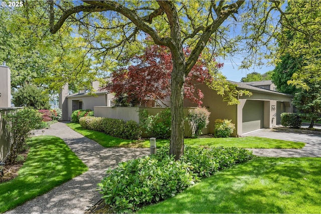 view of front of property featuring stucco siding, a garage, and driveway