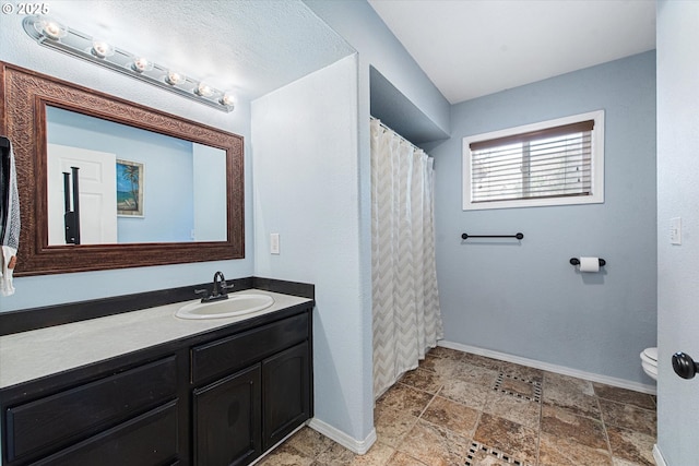 1701 Walnut St, La Grande, OR 97850 - full bathroom featuring vanity, baseboards, toilet, and stone finish floors