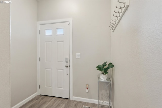 entryway featuring baseboards and light wood-style flooring