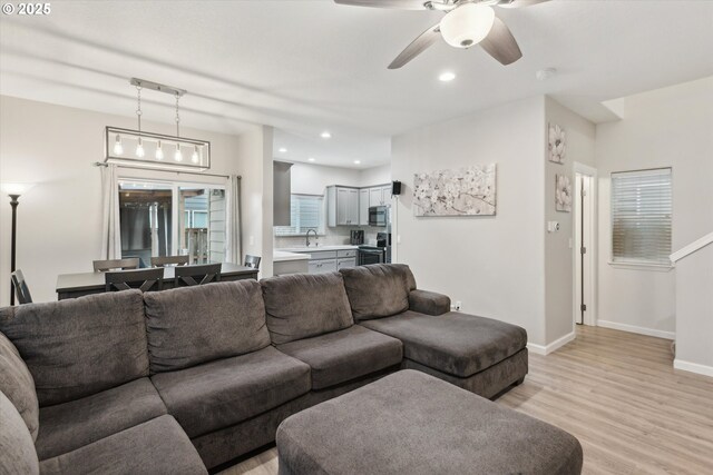 living room featuring recessed lighting, light wood-style flooring, baseboards, and ceiling fan