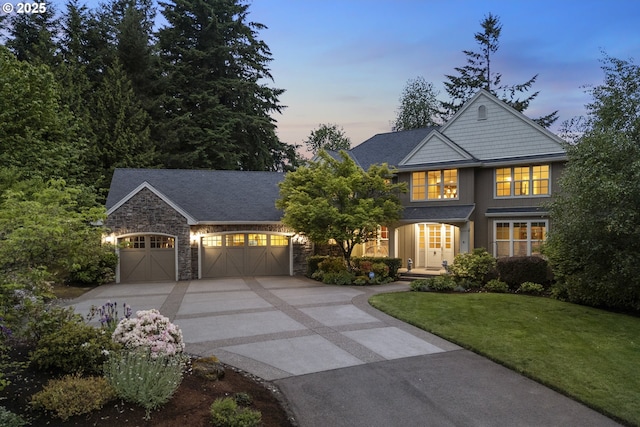 24800 SW Big Fir Rd, West Linn, OR 97068 - view of front of house featuring driveway, a garage, a lawn, and stone siding