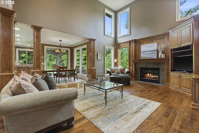 24800 SW Big Fir Rd, West Linn, OR 97068 - living area with a towering ceiling, healthy amount of natural light, a tile fireplace, a chandelier, and dark wood-style flooring