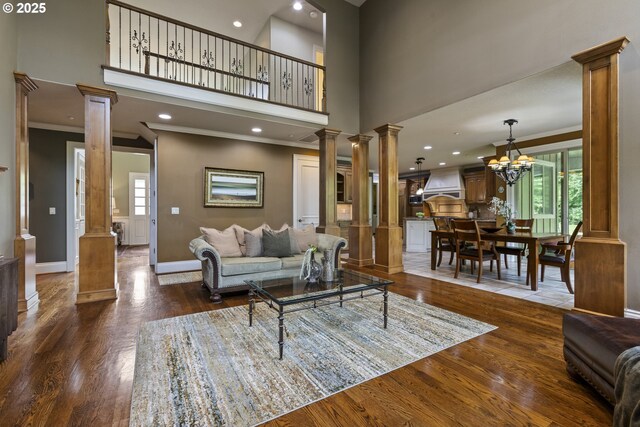 24800 SW Big Fir Rd, West Linn, OR 97068 - living area with ornate columns, healthy amount of natural light, wood finished floors, a high ceiling, and ornamental molding