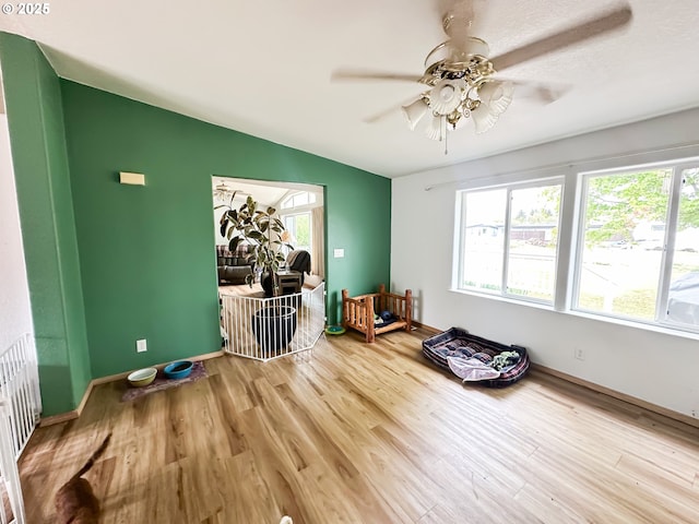 unfurnished room featuring ceiling fan, wood finished floors, and baseboards