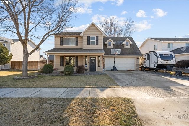 view of front facade with a garage, a front yard, and covered porch