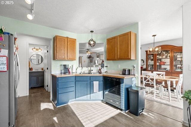 kitchen featuring dark wood-type flooring, sink, decorative light fixtures, stainless steel fridge, and dishwasher