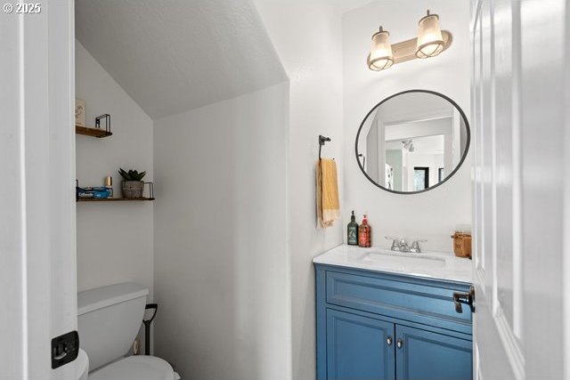 bathroom with vanity, toilet, and vaulted ceiling