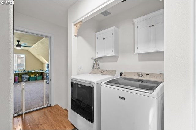 laundry room featuring cabinets, ceiling fan, washing machine and clothes dryer, and light hardwood / wood-style floors