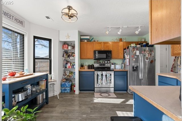 kitchen featuring appliances with stainless steel finishes and dark hardwood / wood-style flooring