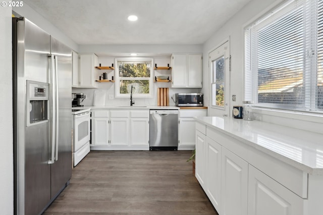 kitchen featuring white cabinetry, appliances with stainless steel finishes, sink, and dark hardwood / wood-style flooring