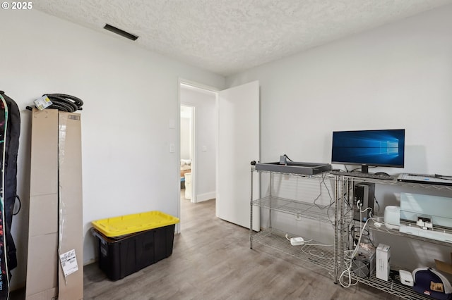 home office with hardwood / wood-style flooring and a textured ceiling