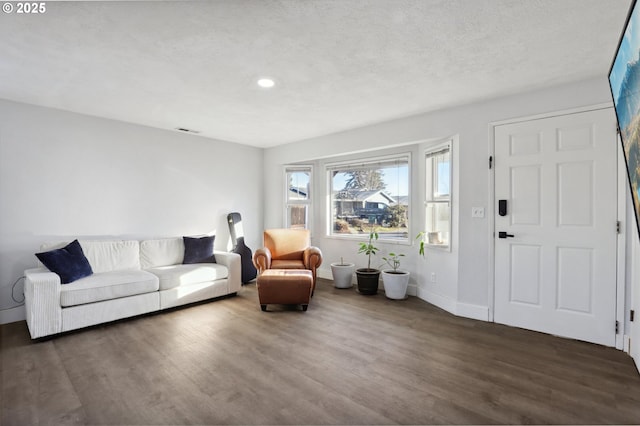 living room featuring dark hardwood / wood-style floors and a textured ceiling