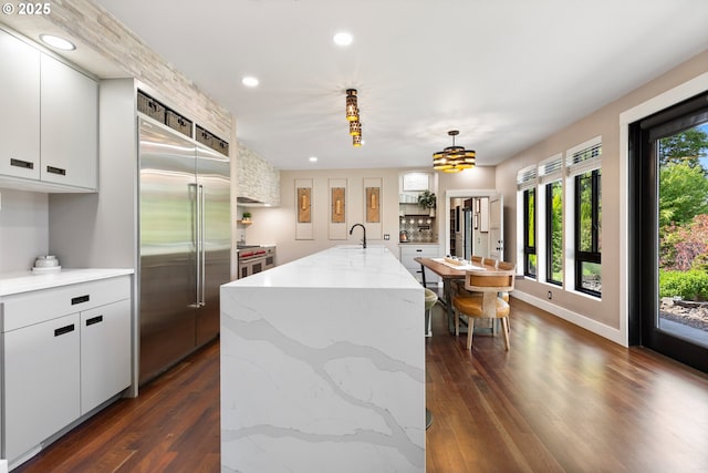22961 SE Filbert Rd, Eagle Creek, OR 97022 - kitchen featuring built in refrigerator, dark wood-style flooring, recessed lighting, white cabinetry, and an island with sink