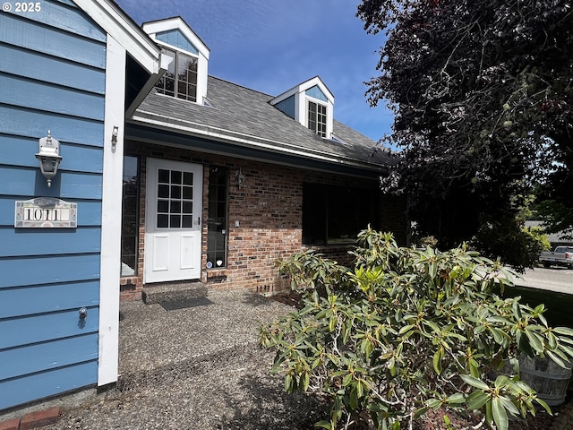 1011 Heather Ct, Reedsport, OR 97467 - property entrance featuring roof with shingles and brick siding