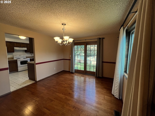 1011 Heather Ct, Reedsport, OR 97467 - unfurnished dining area featuring a textured ceiling, wood finished floors, and a chandelier