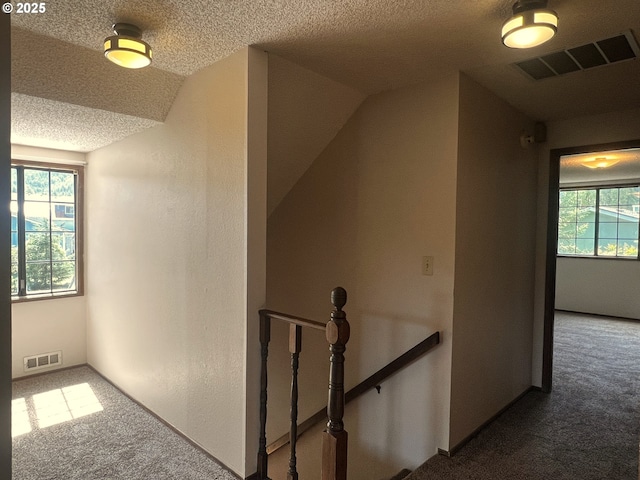 1011 Heather Ct, Reedsport, OR 97467 - hallway with an upstairs landing, carpet flooring, a textured ceiling, and vaulted ceiling