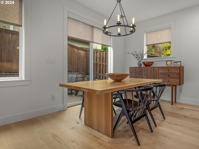 dining space featuring a healthy amount of sunlight, a chandelier, and light wood-type flooring