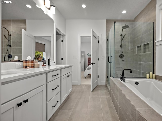 bathroom with tile patterned flooring, vanity, a textured ceiling, and separate shower and tub