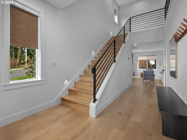 stairs featuring a high ceiling and hardwood / wood-style floors