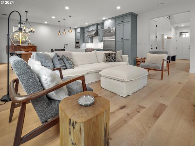 living room featuring a chandelier and light hardwood / wood-style flooring