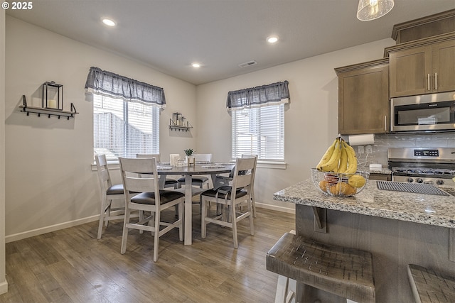 dining space with plenty of natural light and dark hardwood / wood-style flooring