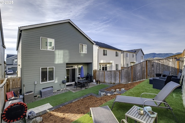 back of house with a patio area, a lawn, and central air condition unit