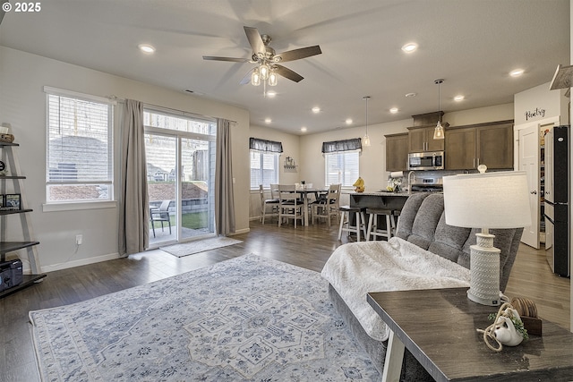 living room with ceiling fan and dark hardwood / wood-style flooring