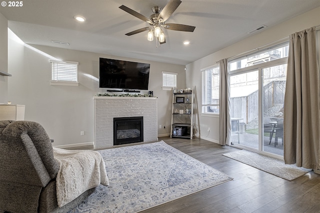 living room with ceiling fan and dark wood-type flooring