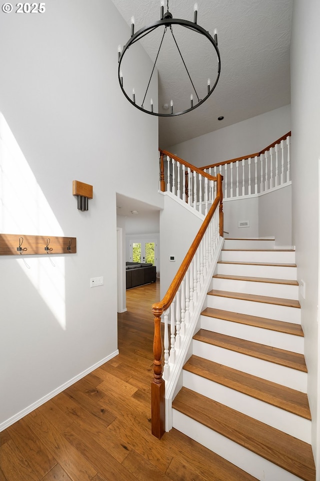 17890 SW 109th Ave, Tualatin, OR 97062 - stairs featuring wood finished floors, baseboards, and a chandelier