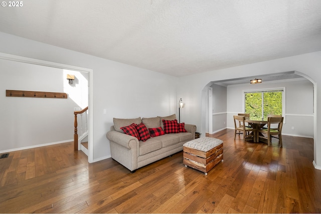 17890 SW 109th Ave, Tualatin, OR 97062 - living room featuring arched walkways, hardwood / wood-style floors, and baseboards