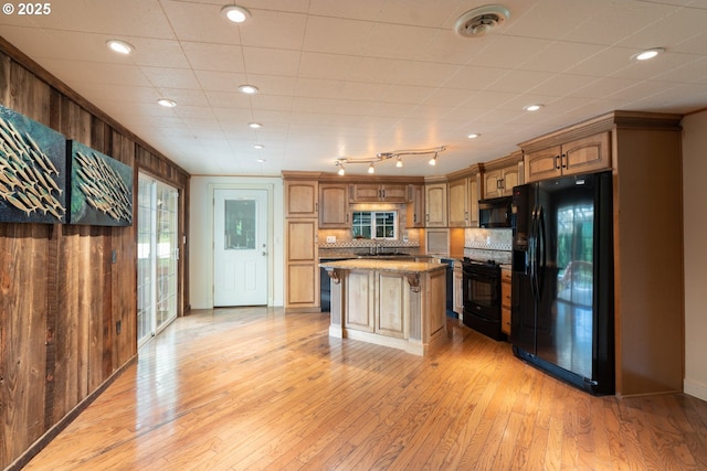 77690 Brock Rd, Oakridge, OR 97463 - kitchen with black appliances, a sink, light wood-style floors, backsplash, and a center island