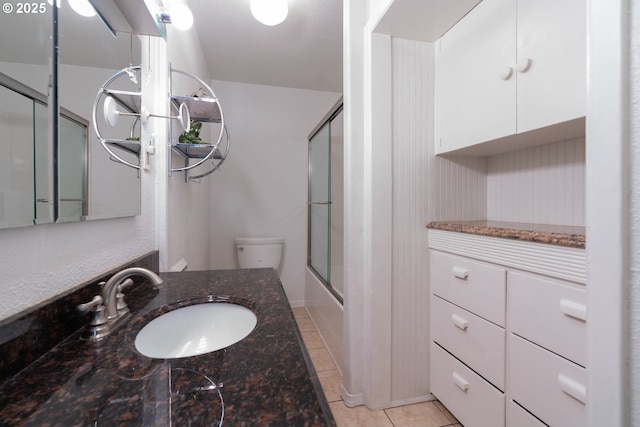 77690 Brock Rd, Oakridge, OR 97463 - full bath featuring combined bath / shower with glass door, vanity, tile patterned flooring, and toilet