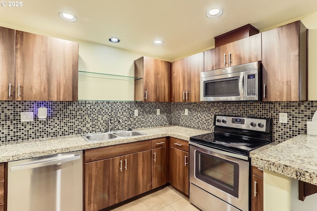 kitchen featuring stainless steel appliances, sink, light tile patterned floors, and backsplash