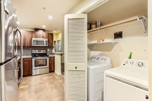 laundry room with light tile patterned floors and independent washer and dryer