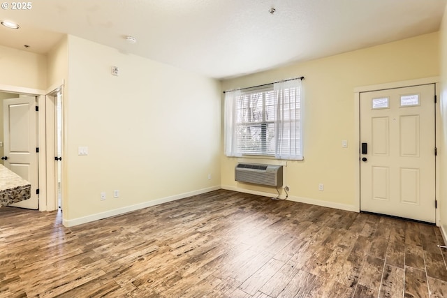 foyer entrance featuring wood-type flooring and an AC wall unit