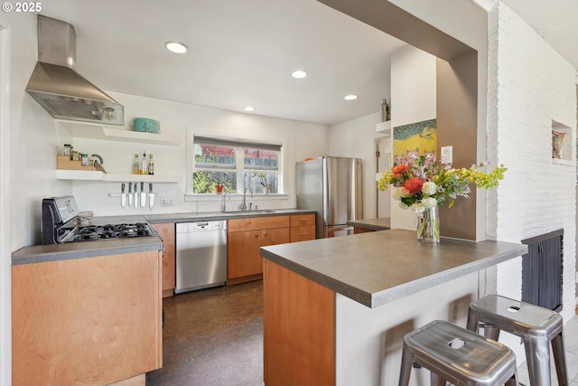 kitchen featuring appliances with stainless steel finishes, wall chimney exhaust hood, a sink, a peninsula, and a breakfast bar