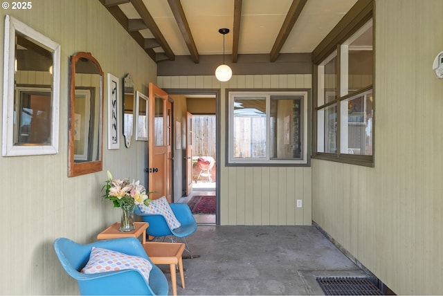 unfurnished sunroom featuring beam ceiling