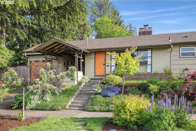 view of front of property featuring a chimney, stairs, and fence