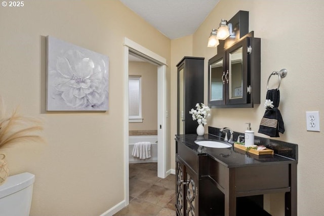 bathroom featuring toilet, vanity, baseboards, and tile patterned flooring