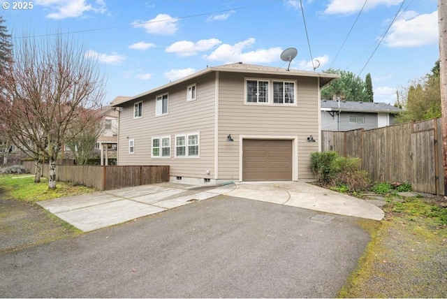 view of front facade with driveway, fence, and an attached garage