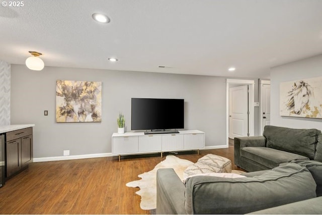 living room with baseboards, wood finished floors, and recessed lighting