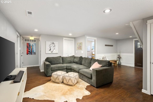 living room with dark wood-style flooring, recessed lighting, wainscoting, and baseboards